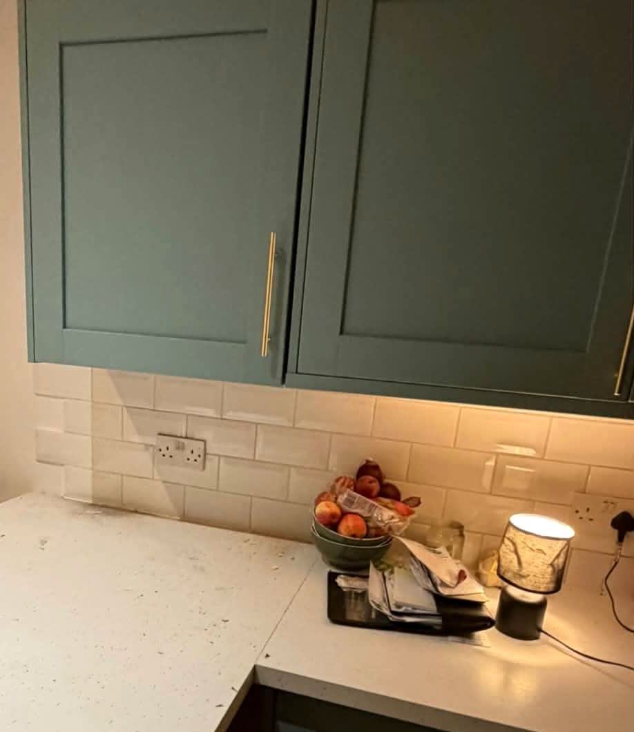 Green shaker wall cabinets fitted above a worktop