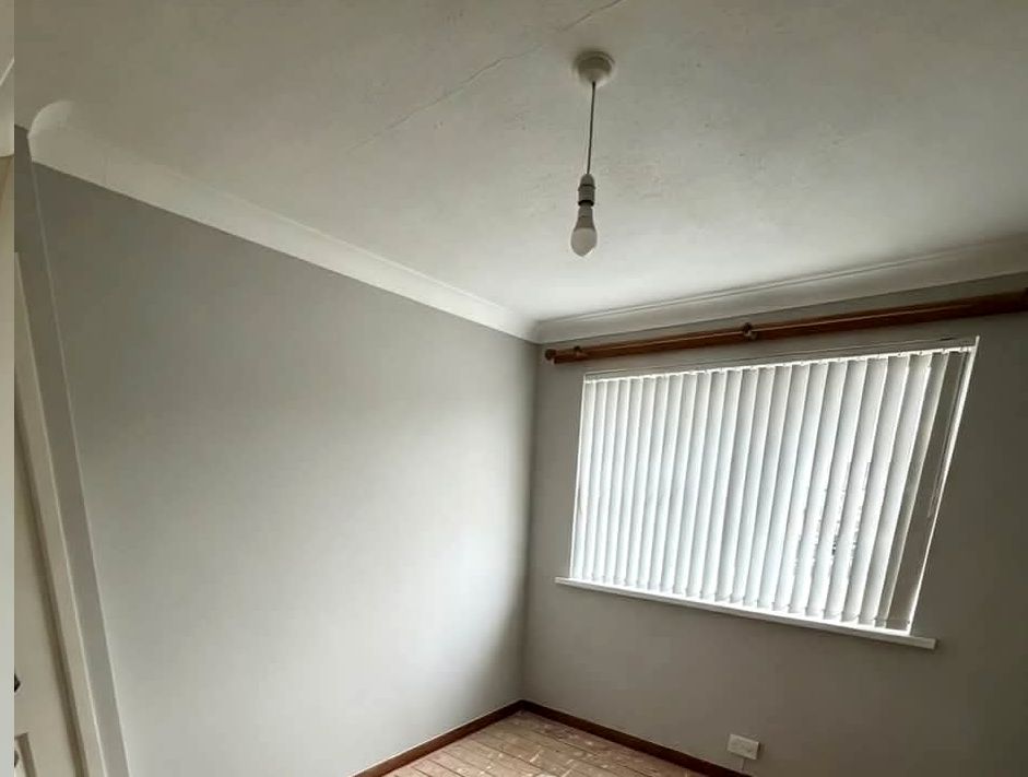 Same bedroom painted light grey with vertical blind