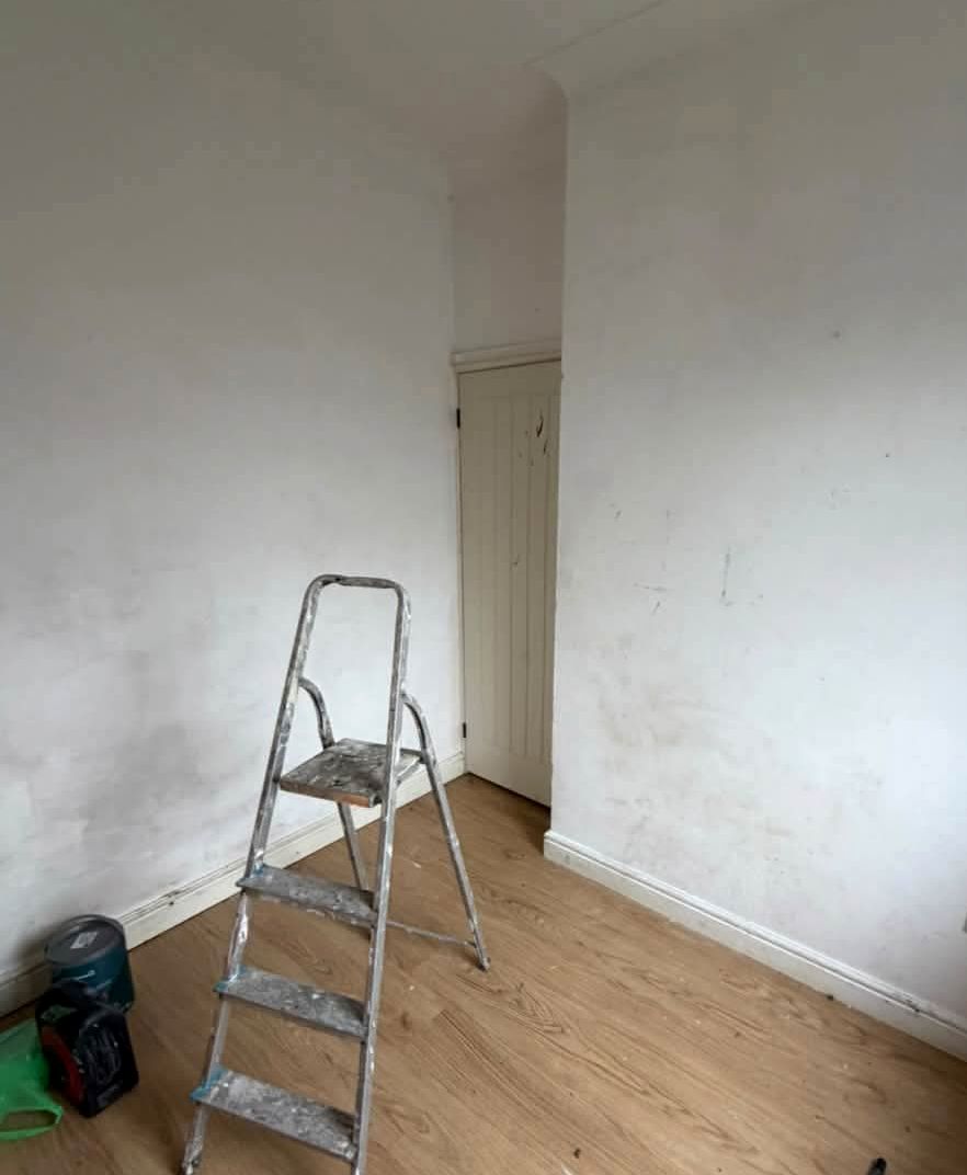 White box bedroom with a stepladder before painting