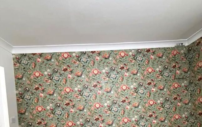 Room finished in green floral wallpaper
