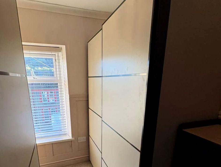 Fitted wardrobe with white sliding doors closed